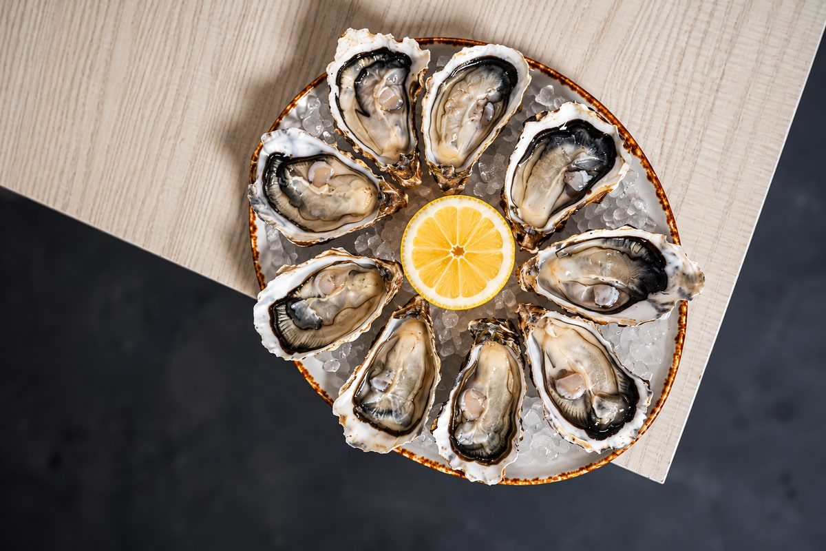 Plato de ostras con limón servido en la barra de Chao Pescao